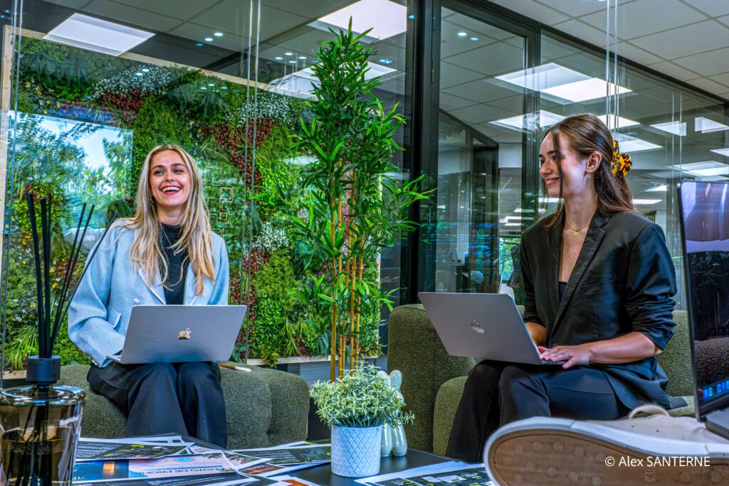Deux collaboratrices avec leurs ordinateurs portables dans un espace de travail